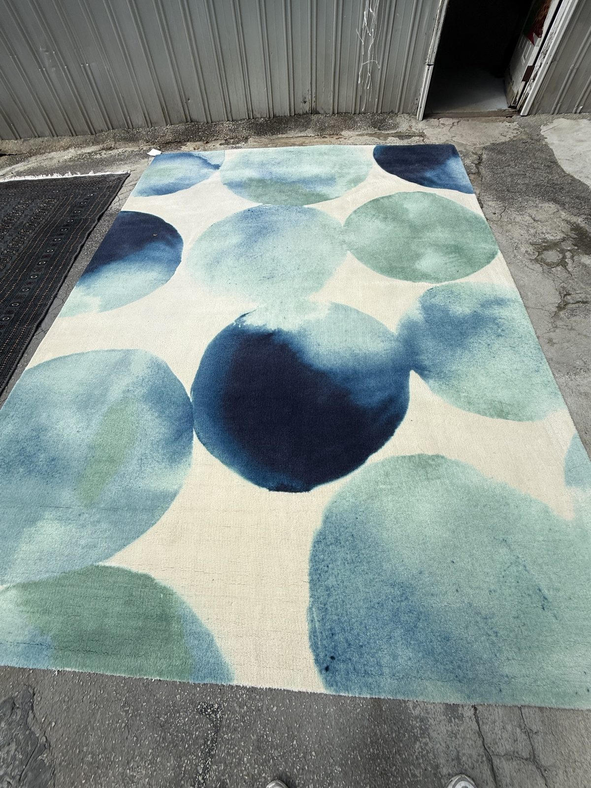 Hand-tufted modern wool rug drying outdoors after cleaning